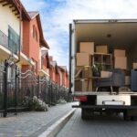 Van,Full,Of,Moving,Boxes,And,Furniture,Near,House