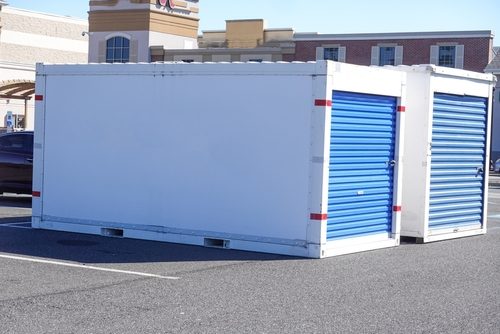 Two,White,Storage,Pods,With,Blue,Doors,On,A,Asphalt